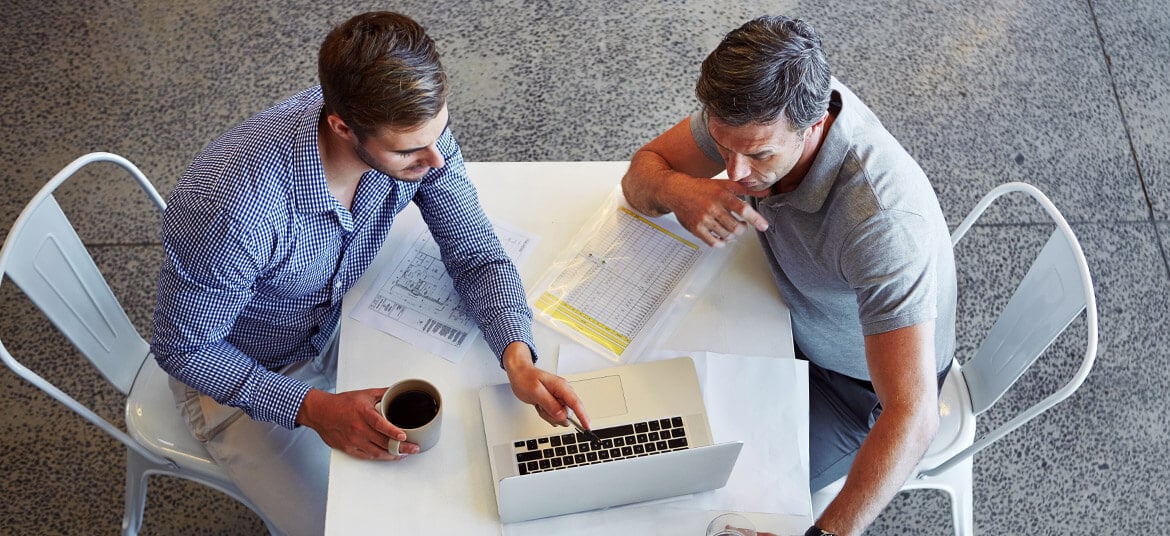 Businessmen at a computer calculating APR vs Simple Interest Rate using the simple interest rate formula