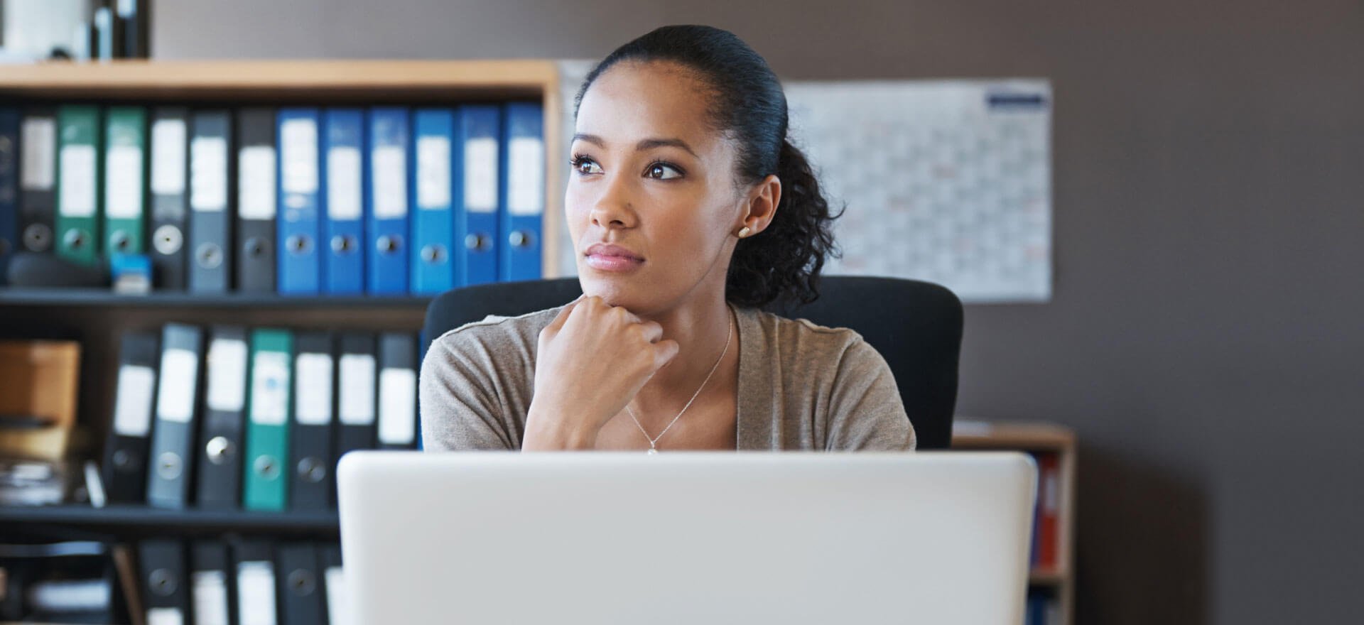 Woman at computer thinking about how to get a business loan.