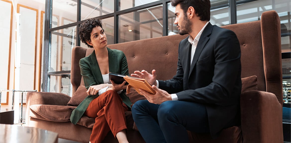 Accountand and his client sitting on a couch discussing taxation issues