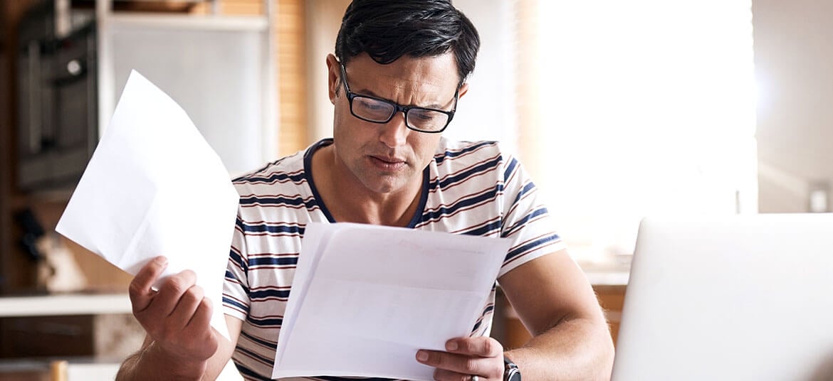 Picture of man examining papers with current liabilities