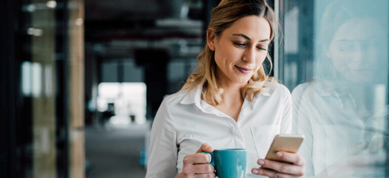 Woman looking at a mobile phone thinking about e-invoicing