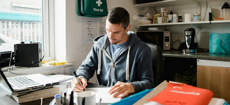 Man sitting at desk writing a business plan